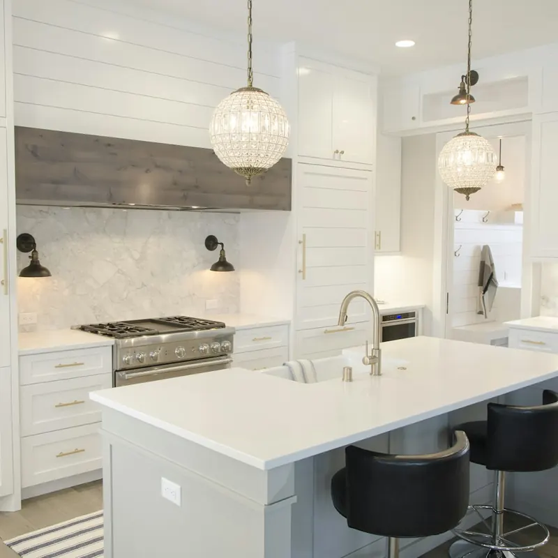 Cocina blanca con isla y lámparas de cristal