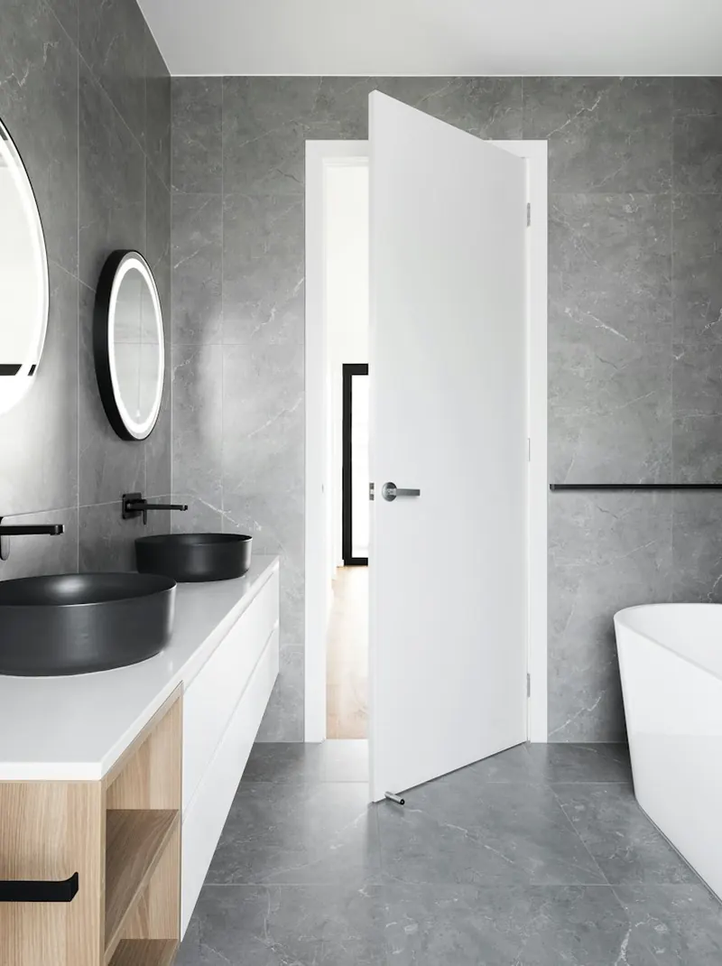 Baño terminado en gris con bañera exenta